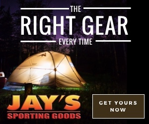 Tent lit up from inside outside in the dark wilderness promoting Jay's Sporting Goods
